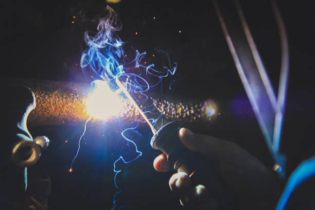 istock Welder welding metal in workshop with sparks 1052073642