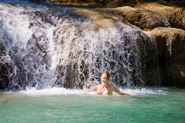 istock Girl bathing Kuang Si waterfall 1052074202