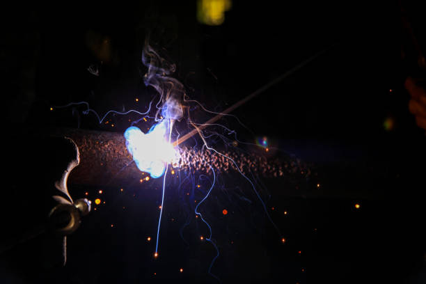 istock Welder welding metal in workshop with sparks 1052076044