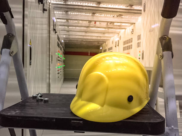 желтый защитный шлем в электрической комнате, расположенной под поднятым полом - mezzanine installation стоковые фото и изображения