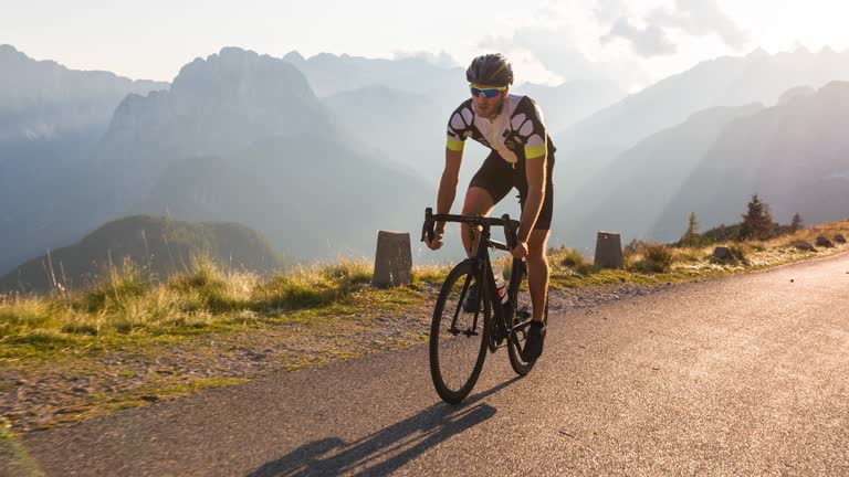 Professional road cyclist cycling uphill in mountains