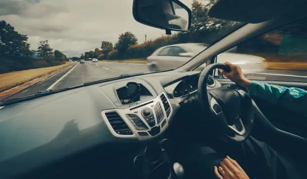 Photo of A female driver driving a car along a busy road