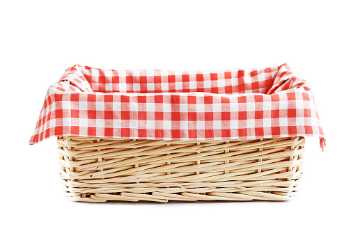 Empty straw basket with checkered red linen isolated.