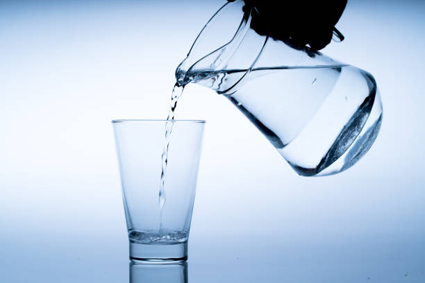 istock Close up pouring drinking water into glass, studio shot 1052168026