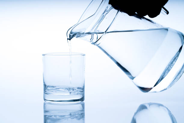 istock Close up pouring drinking water into glass, studio shot 1052168500