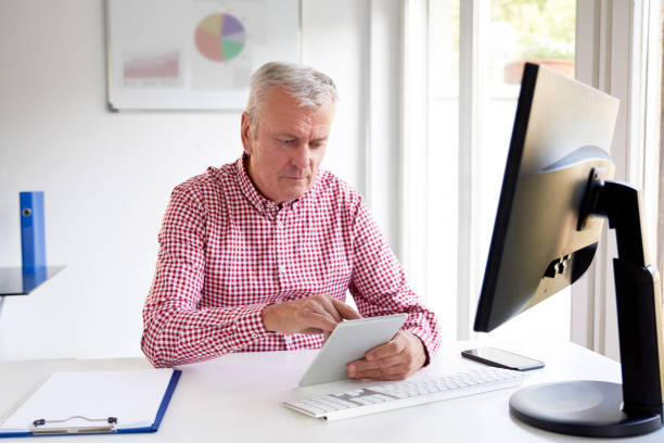 istock Elderly businessman working on digital tablet 1052173140