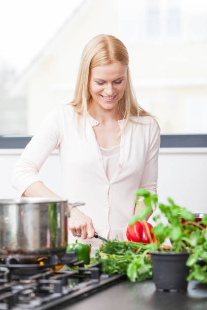 istock woman in the kitchen cutting vegetables. 1052206190