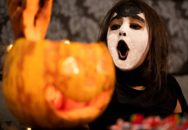 istock little girl opening Halloween pumpkin. 1052221776