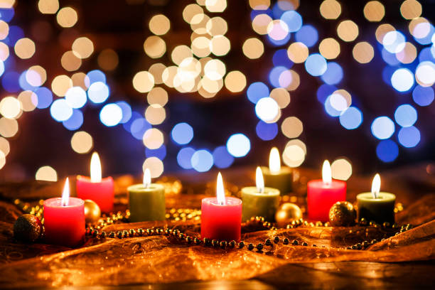 istock Low key of lit candles on defocused Christmas lighting background 1052242334