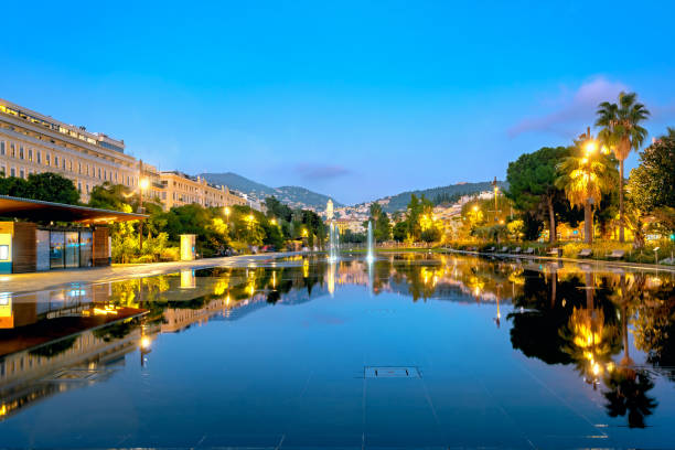 fontana con riflesso speculare della città notturna in place massena a nizza. francia - city of nice france massena city foto e immagini stock