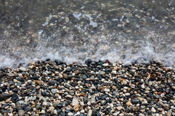 istock Natural pebbles and sea water background. 1052277356