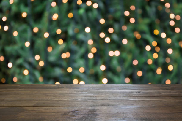 istock Blurred gold garland and wooden tabletop as foreground. Image for display or montage your christmas products. 1052299208