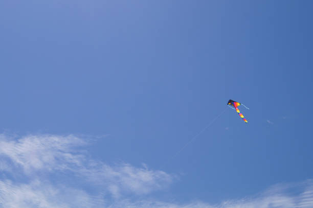 istock Flying kite into the Sun on a summer blue sky background 1052303710