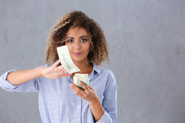istock Beautiful black woman portrait. Scattering money notes 1052346012