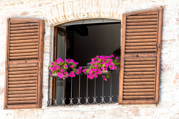 assisi, italie village ou ville en ombrie, agrandi d’ouvrir la fenêtre volets balcon et décorations florales rose sur journée d’été ensoleillée, personne, architecture - rose window assisi wall umbria photos et images de collection