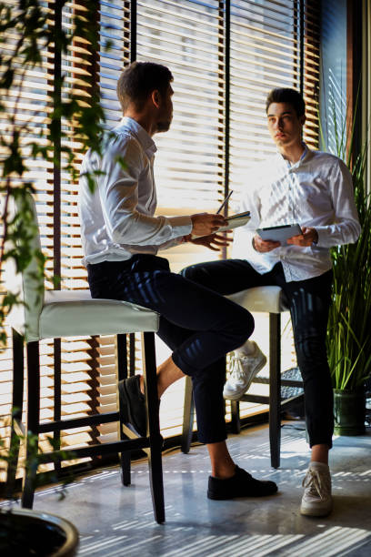 istock Trendy businessmen sitting and talking 1052347230