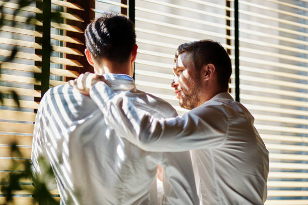 Young friendly businessmen standing near window