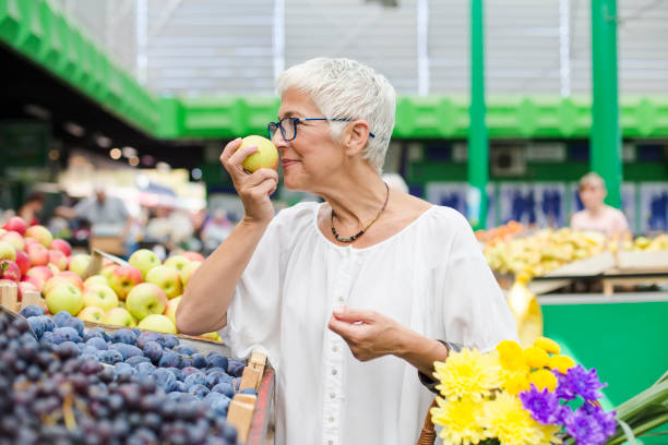 istock Senior woman buying fruit on market 1052362276