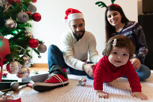 Beautiful latin american couple having fun celebrating christmas and little baby girl smiling at camera very happy