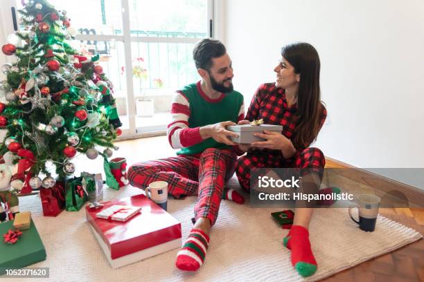 美しい若いカップル交換クリスマス プレゼント クリスマス パジャマを着て - 2人のストックフォトや画像を多数ご用意 - 2人, 30代, アルゼンチン