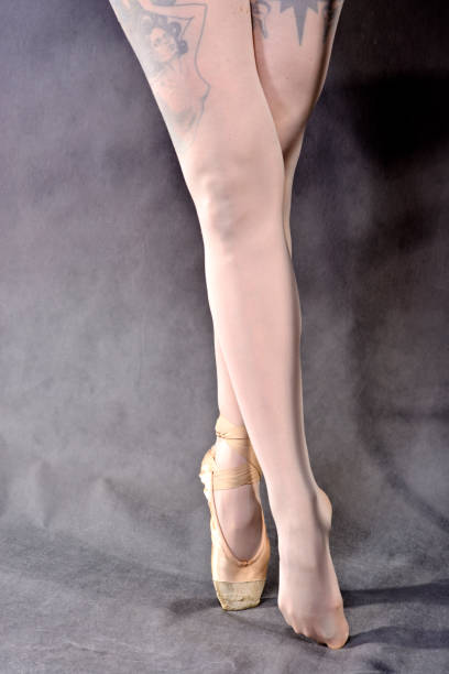 istock Ballerina legs in pointe shoes on grey background. 1052379172