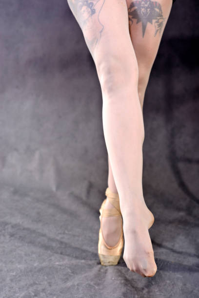 istock Ballerina legs in pointe shoes on grey background. 1052379264
