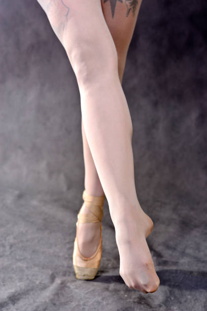 istock Ballerina legs in pointe shoes on grey background. 1052379310