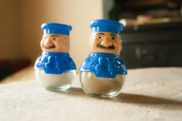 Salt and pepper shakers in the shape of cooks on the table