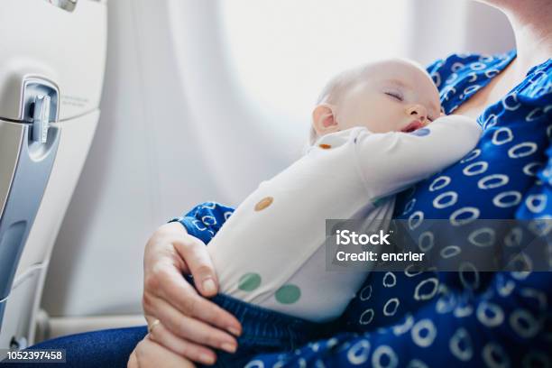 Mujer Con Niña Viajar En Avión Foto de stock y más banco de imágenes de Bebé - Bebé, Avión, Viajes