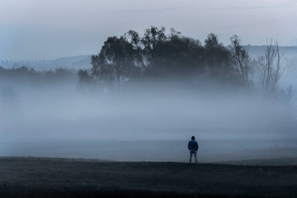 istock Man standing alone in the foggy nature 1052430406