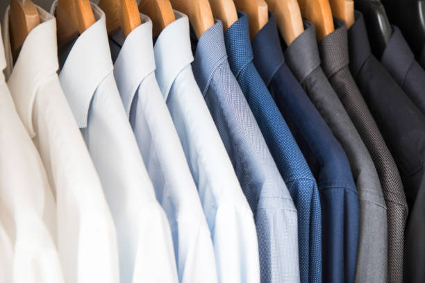 istock Office Business shirts hanging in a closet ordered by colour 1052453836