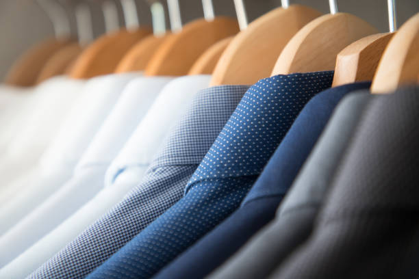 istock Office Business shirts hanging in a closet ordered by colour 1052453842