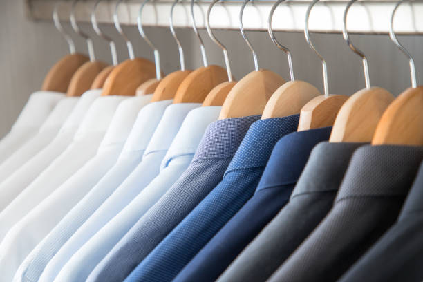 istock Office Business shirts hanging in a closet ordered by colour 1052454446