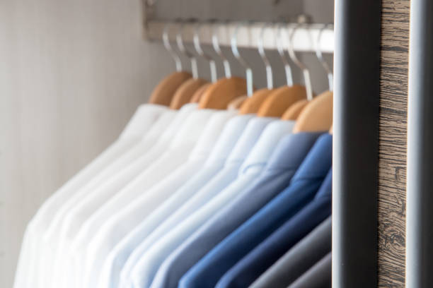 istock Office Business shirts hanging in a closet ordered by colour 1052454906