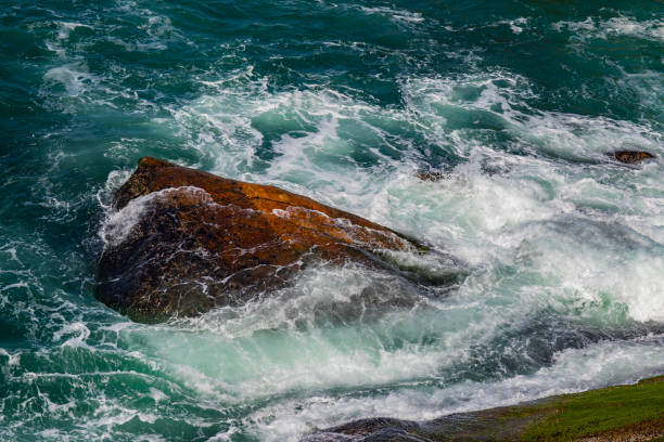 istock Deep blue sea waves hit cliff. Sea waves hit rocks cliff. Mighty sea waves breaking on a cliff. 1052458126