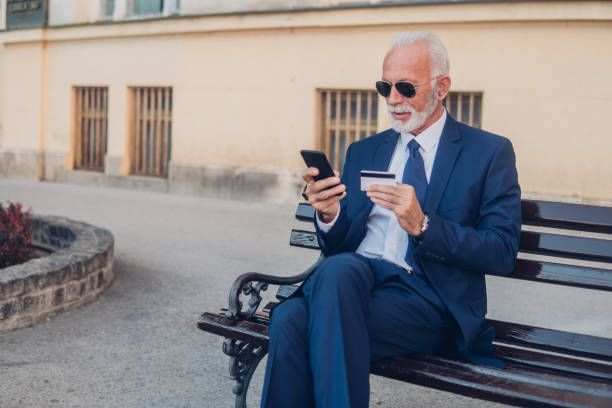 istock Old man with credit card 1052495598