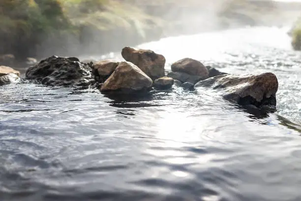 Photo of Closeup view of Hveragerdi Hot Springs on trail in Reykjadalur, during autumn summer morning day in south Iceland, golden circle, rocks and river steam