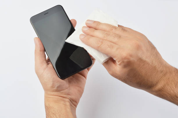 istock Man cleaning his smartphone with a microfiber cloth 1052528230