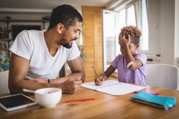 istock Father helping daughter with homework at home 1052569670