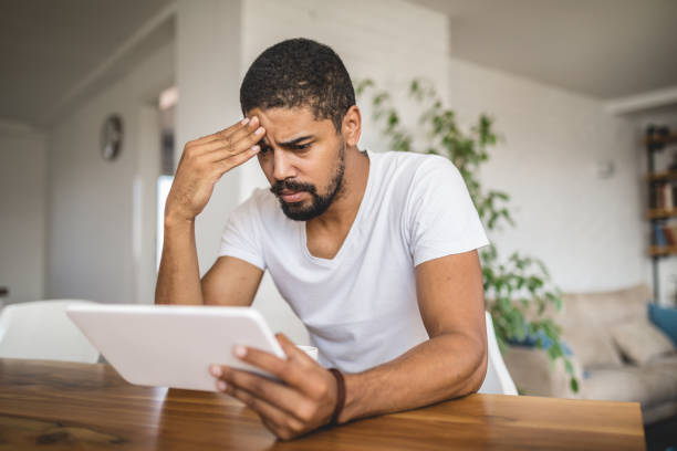 Worried mixed race person holding a digital tablet