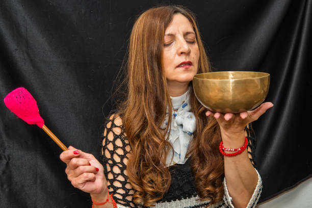 frau spielt ein singender schalen auch tibetischen klangschalen, himalaya-schalen. - music wellbeing rin gong bowl stock-fotos und bilder