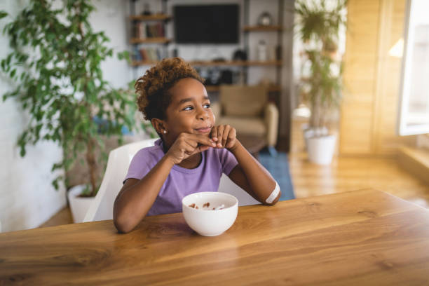 Cheerful daughter eating breakfast