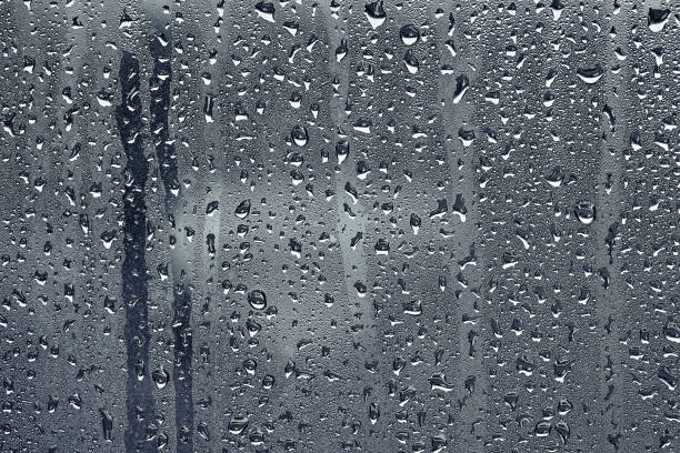 istock rain drops on glass clear window close up rain drop background. 1052664176