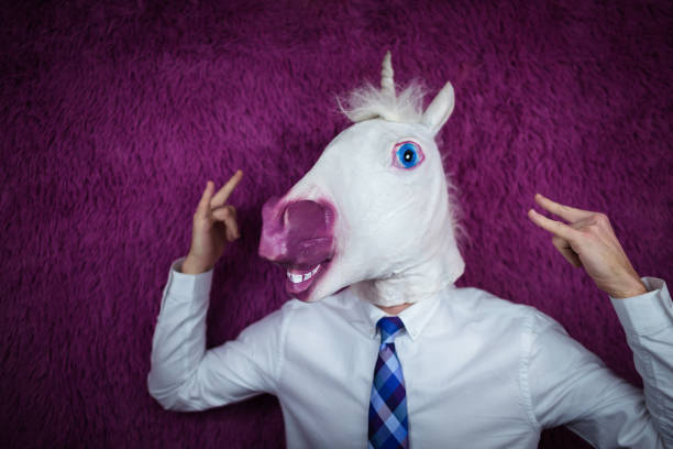 istock Freaky young man in comical mask stands on the purple background 1052664226