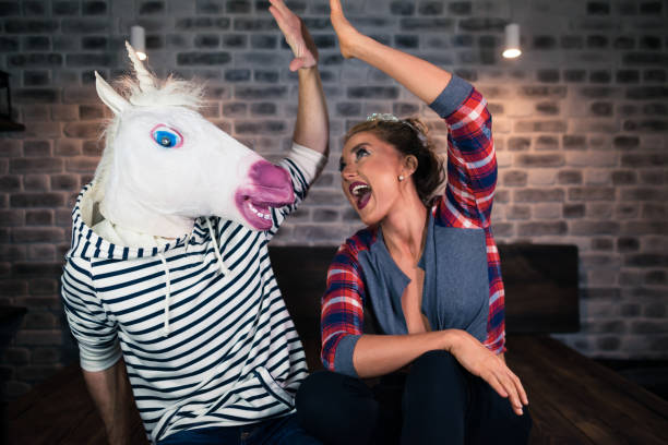 istock Happy young woman with funny man in comical mask 1052664282