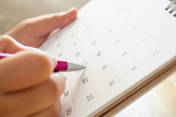 istock calendar page with female hand holding pen 1052675614