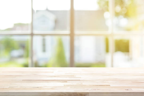 istock Wood table top with window and morning sunlight in background 1052676812