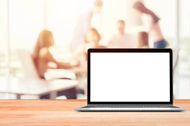 istock Laptop with blank screen placed on wooden table Blurred people meeting background ,Startup Business plan and discussing concept background 1052715632