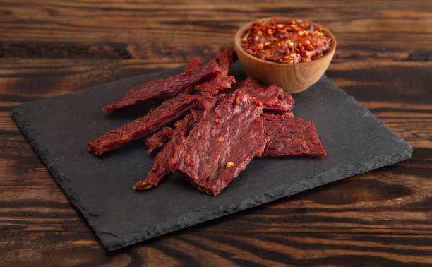 a pile hot and spicy beef jerky with red pepper flakes - beef jerky meat smoked imagens e fotografias de stock
