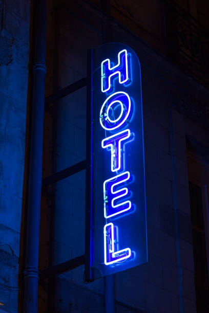 синий неоновый знак отеля в ночное время - sign building exterior vertical social grace стоковые фото и изображения